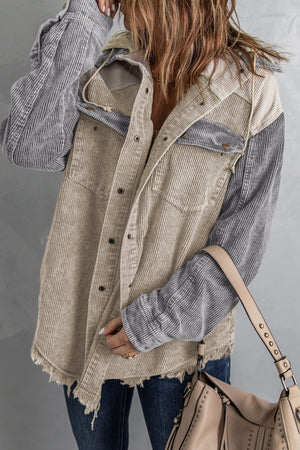 Colorblock corduroy hooded utility jacket with tan and gray panels and frayed hem.