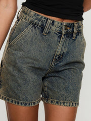 Utility denim carpenter shorts in a distressed blue wash with brass button detail.