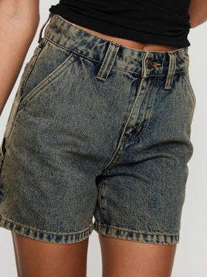 Utility denim carpenter shorts in a distressed blue wash with brass button detail.