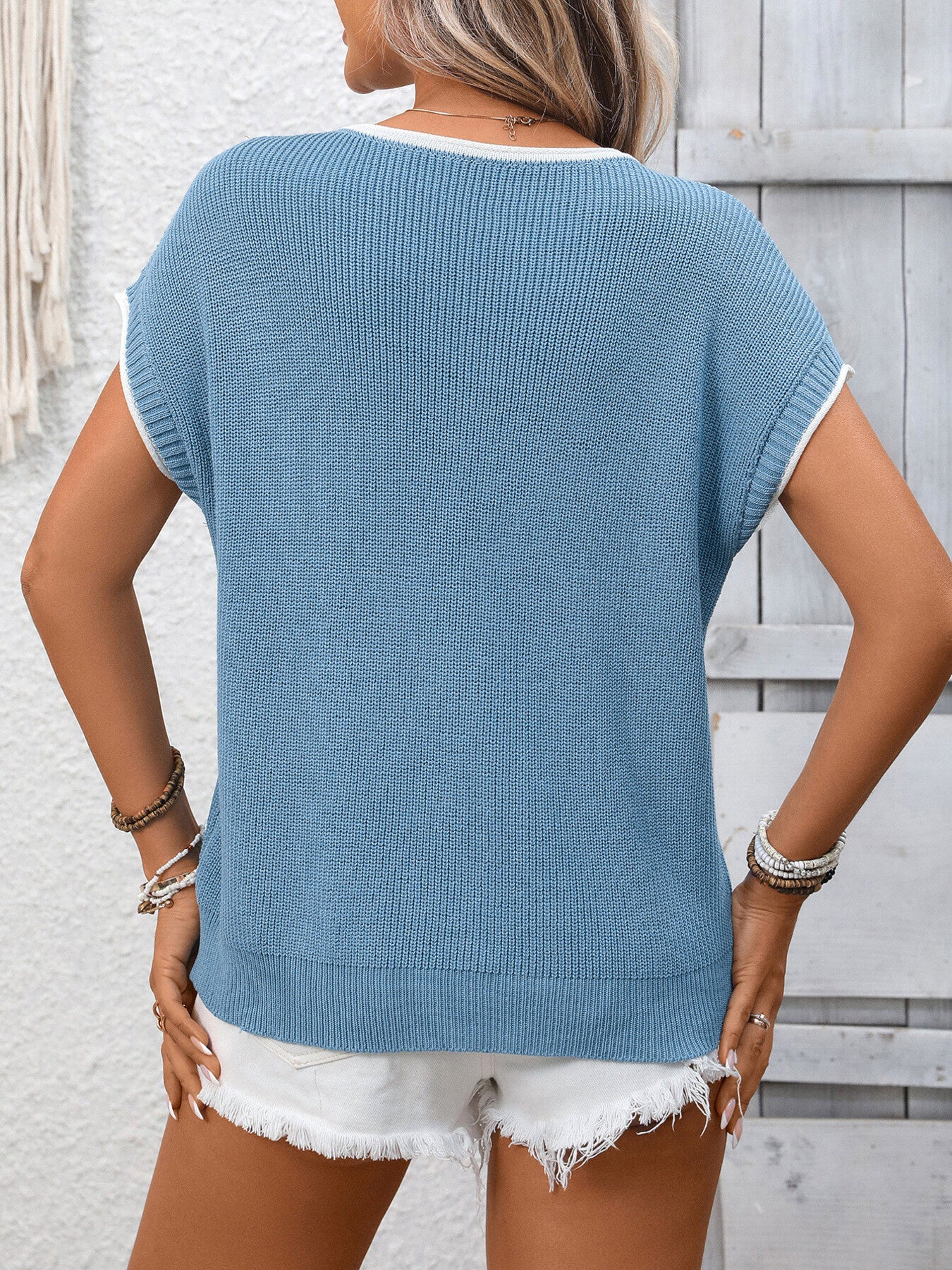 Blue ribbed knit short-sleeve sweater top with white trim, worn with white shorts.