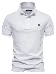 White cotton polo shirt with embroidered crest detail and button placket.