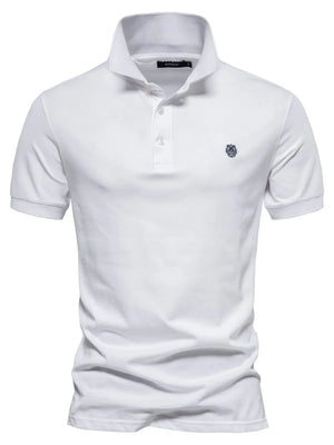 White cotton polo shirt with embroidered crest detail and button placket.