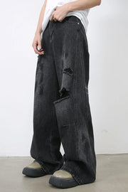 Dark wash relaxed fit denim jeans with distressed rips and wide leg.