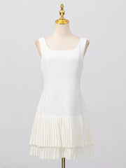 White square neck sleeveless mini dress with layered pleated hem detail.
