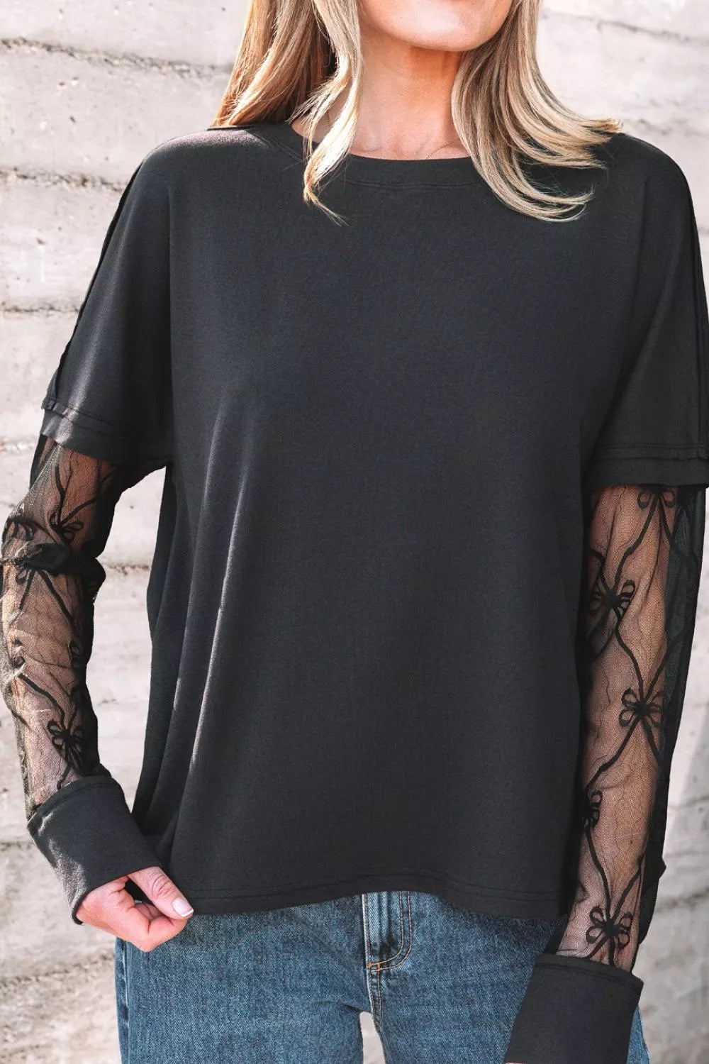 Black relaxed fit t-shirt with lace sleeves featuring bow details.