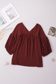 Textured gauze blouse in burnt coral with V-neck and gathered balloon sleeves.