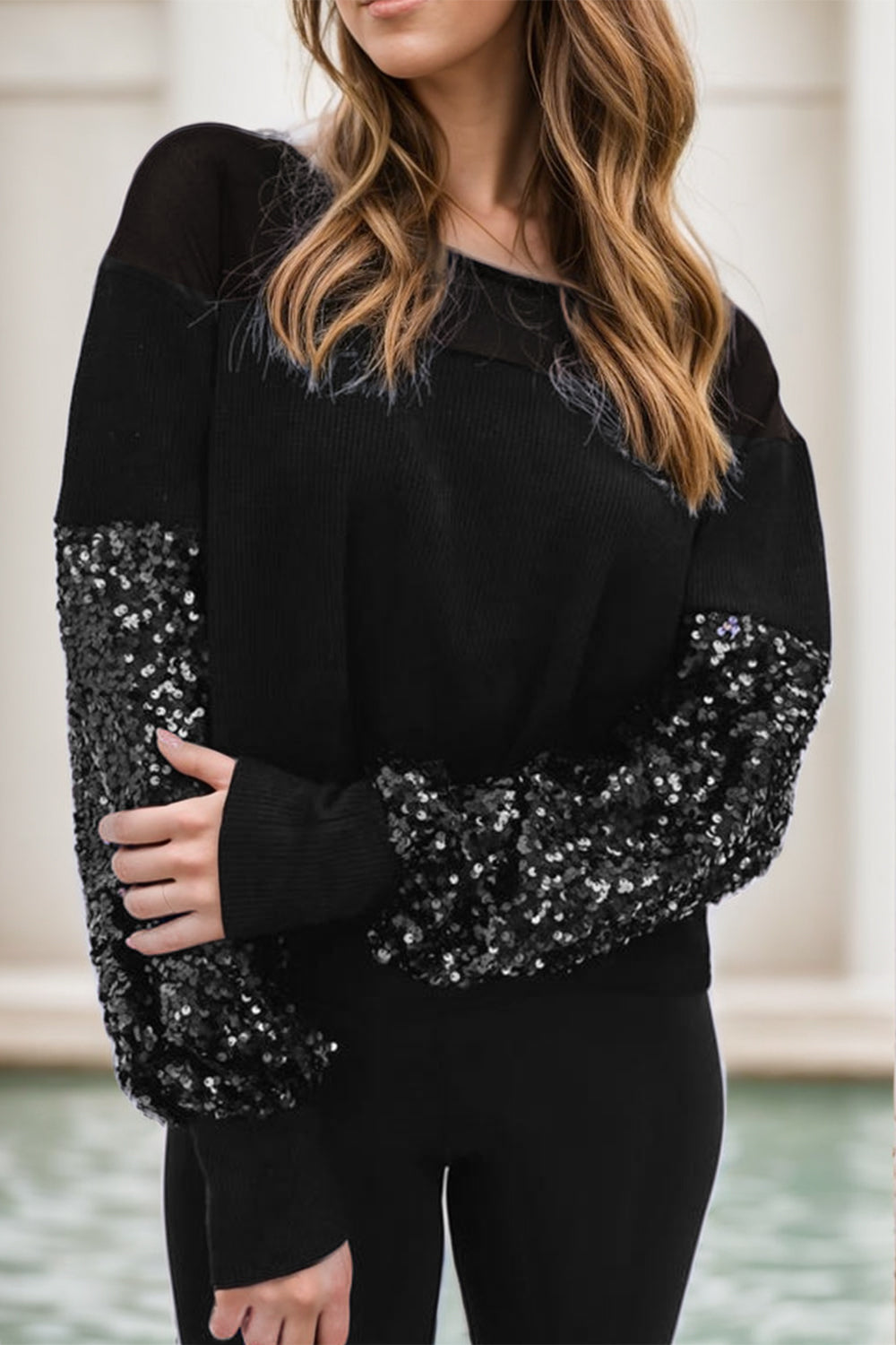Black ribbed knit sweater with sequin sleeves and boat neck