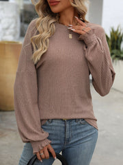 Textured ribbed knit blouse in a taupe color with ruffled cuffs and balloon sleeves.