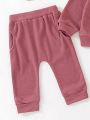 Toddler dusty rose waffle knit pants with elastic waist and pockets.