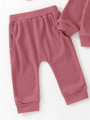 Toddler dusty rose waffle knit pants with elastic waist and pockets.