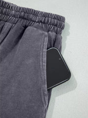 Maternity cropped wide-leg pants in charcoal cotton with elastic waist and side pocket holding a phone.