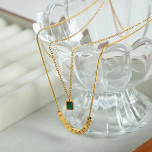 Gold layered necklace with emerald cube pendant and gold bead accents