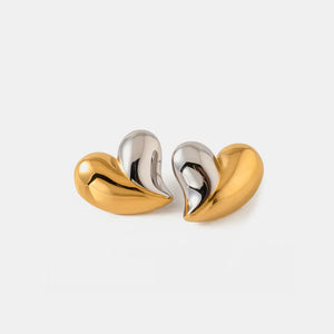 Two-tone heart sculptural stud earrings in gold and silver.