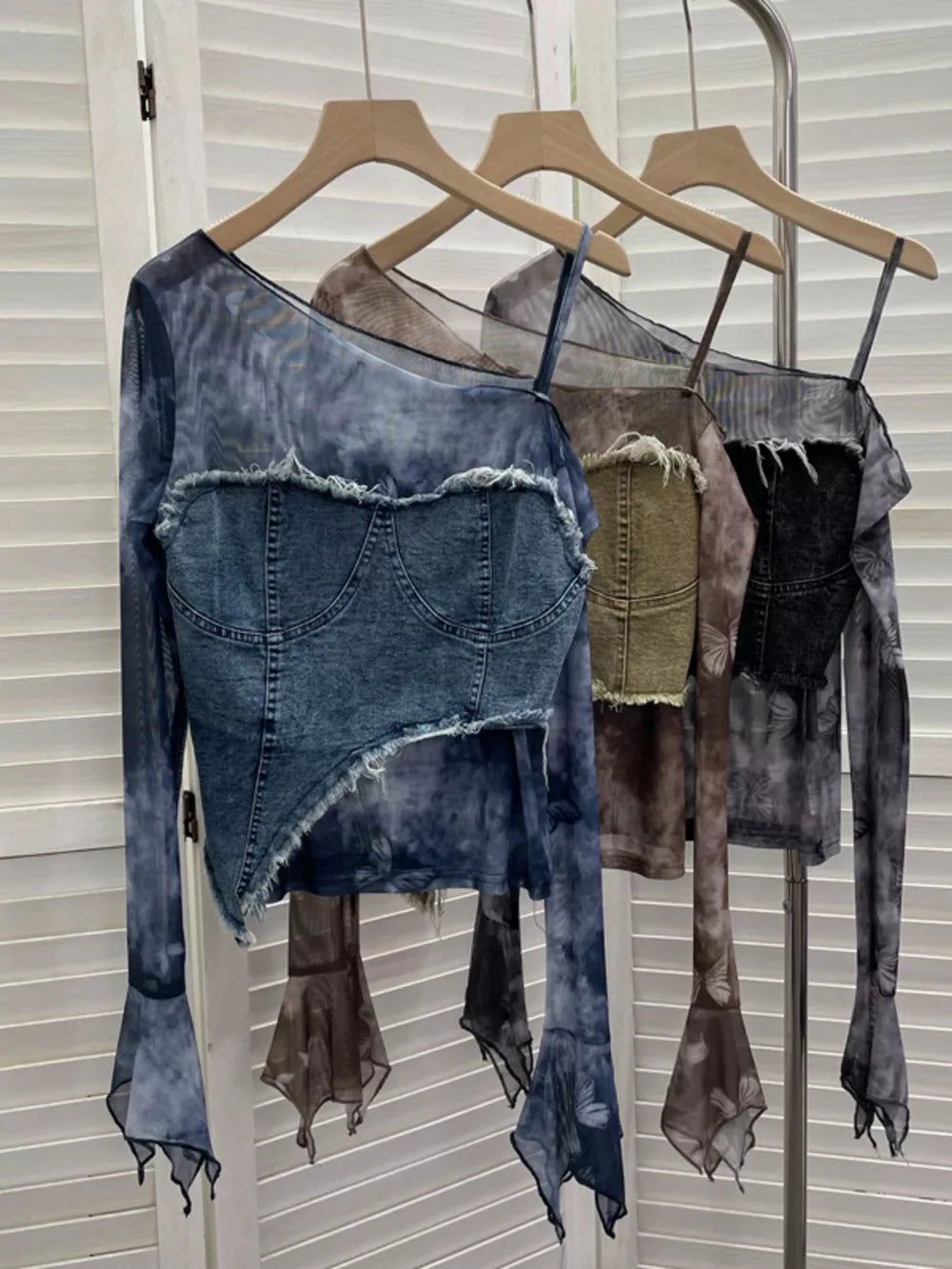Edgy asymmetrical denim layered t-shirt in blue with sheer butterfly print sleeves and frayed hem.