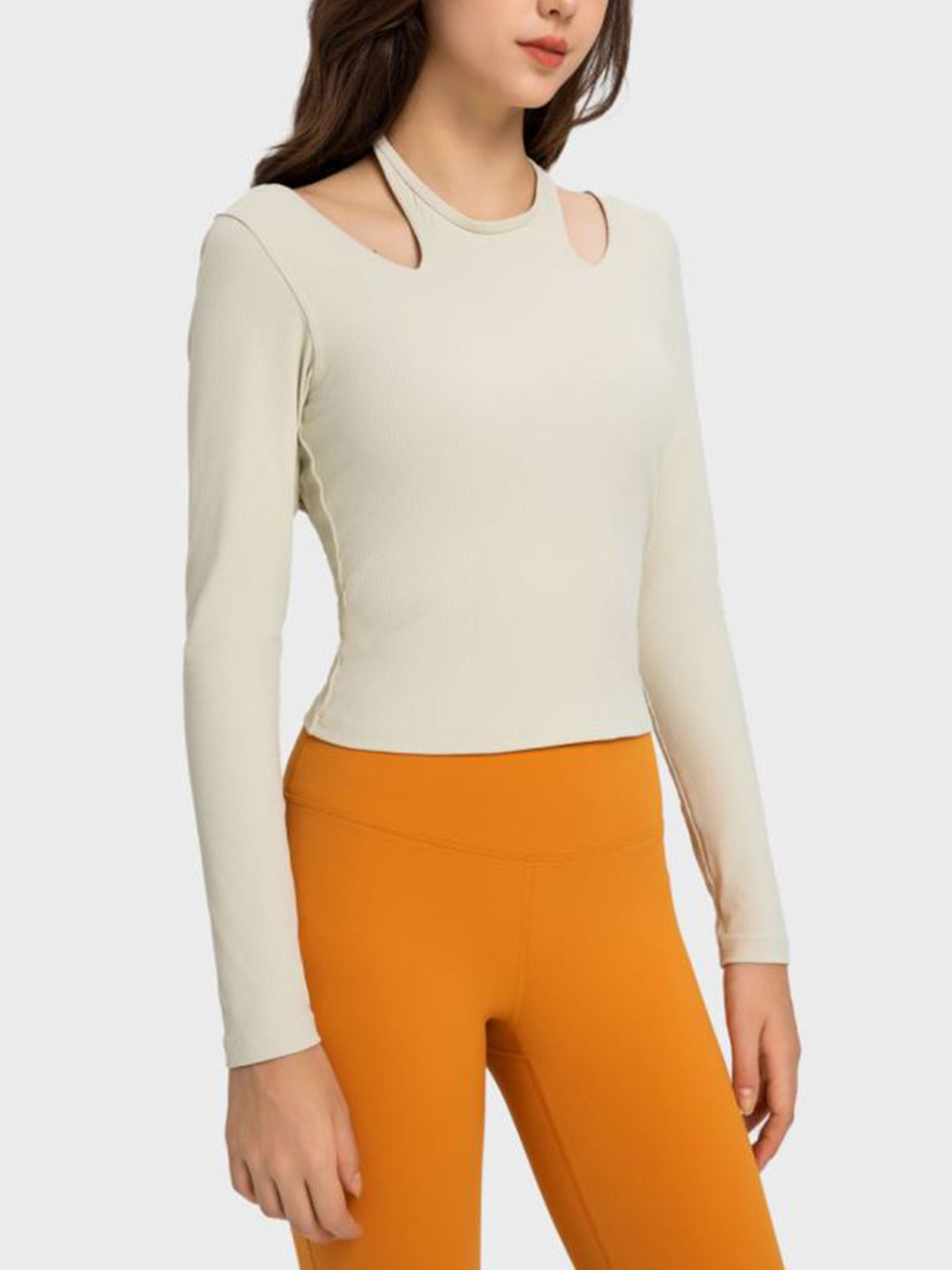 Ivory ribbed long sleeve sport top with cutout shoulders and crew neck.