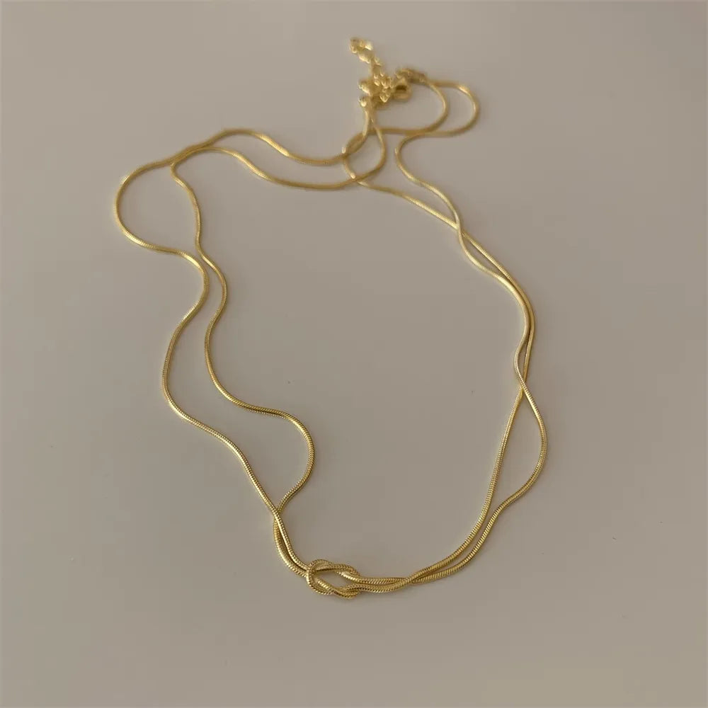 Gold snake chain necklace with a knot detail