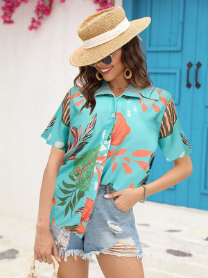 Aqua tropical print camp collar shirt with short sleeves and button front, styled with denim shorts.