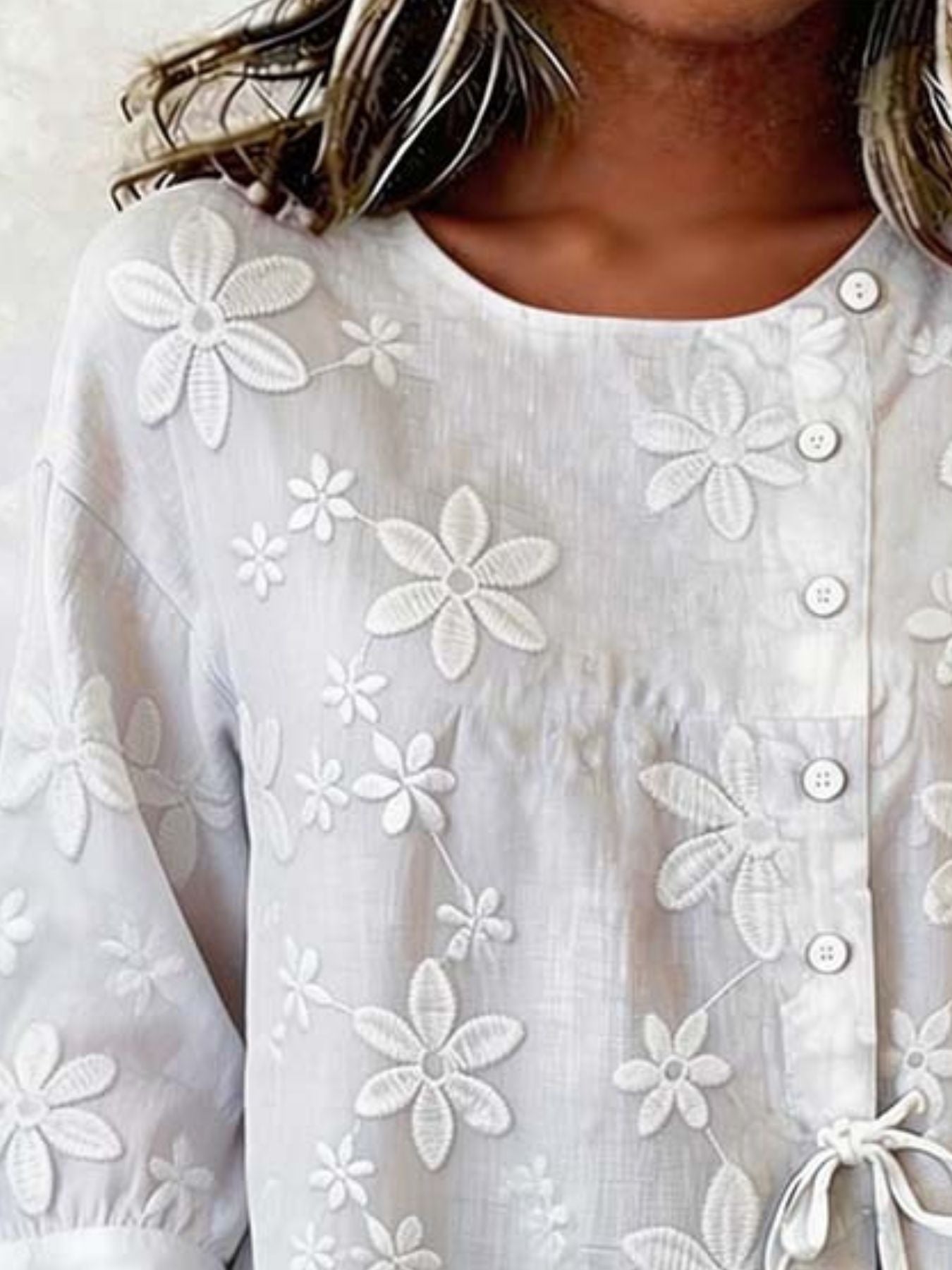 White button-down blouse with 3/4 sleeves and embroidered floral details.