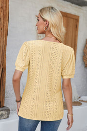 Light yellow perforated puff sleeve henley blouse with eyelet detail.