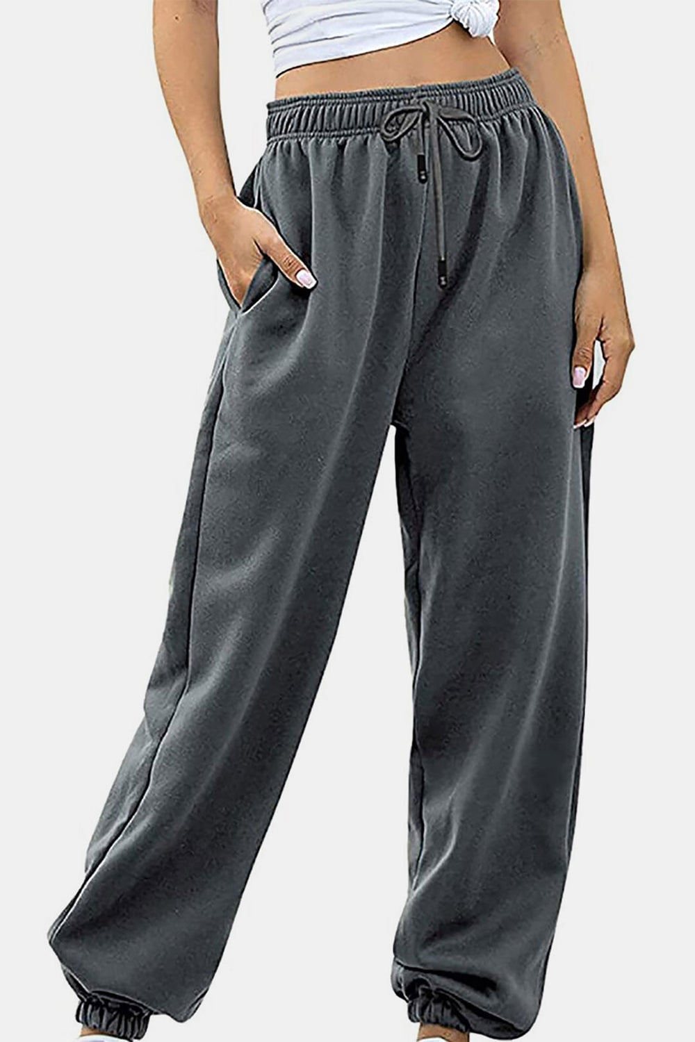 Relaxed-fit cuffed sweatpants in dark gray with a drawstring waist and side pockets.