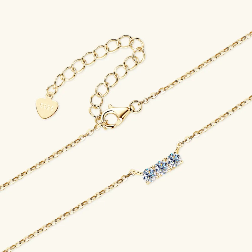 Gold bar necklace with three moissanite stones and adjustable chain.