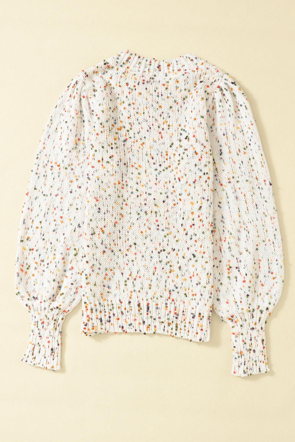 Speckled puff sleeve knit sweater in cream with colorful speckles and ribbed cuffs.