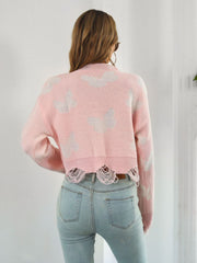 Blush pink distressed knit cropped sweater with white butterfly print and frayed hem.
