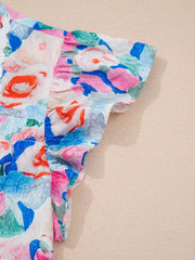 Vibrant floral cotton blouse with ruffled short sleeves and a tie neck detail.