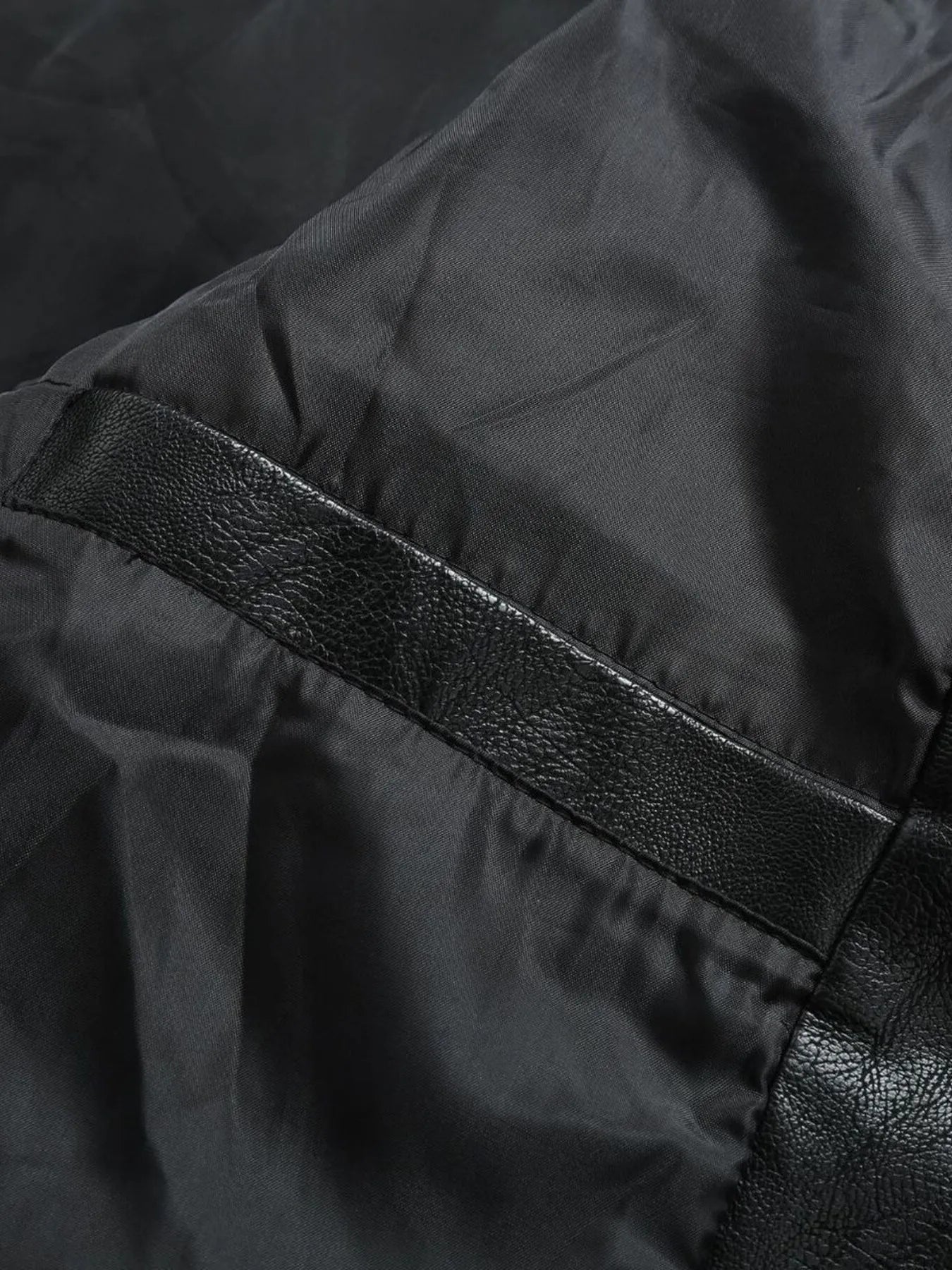 Black moto jacket detail with faux leather trim and satin lining.