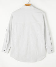 Relaxed white button-down shirt with subtle vertical pinstripes and roll-tab sleeves.