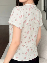 White floral blouse with puff sleeves and lace trim detail.