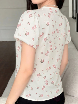 White floral blouse with puff sleeves and lace trim detail.