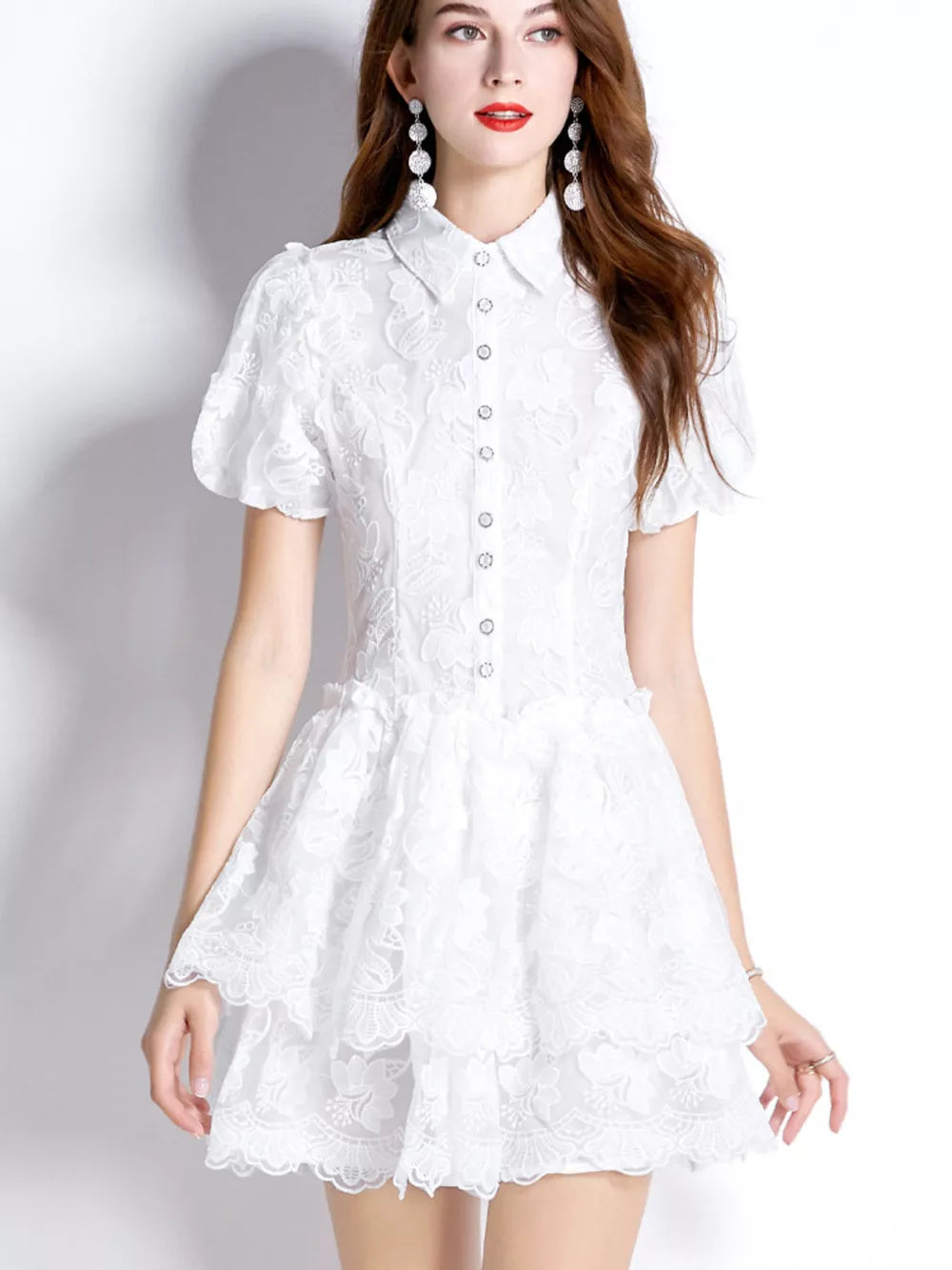 White lace mini dress with puff sleeves, button front, and tiered ruffled skirt.