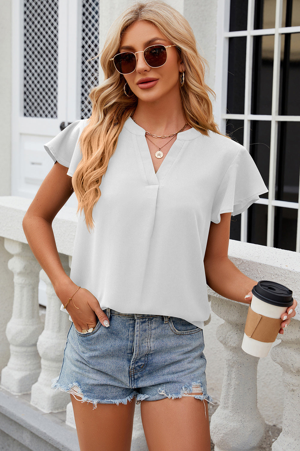 White flutter sleeve V-neck blouse with a relaxed fit and casual styling.