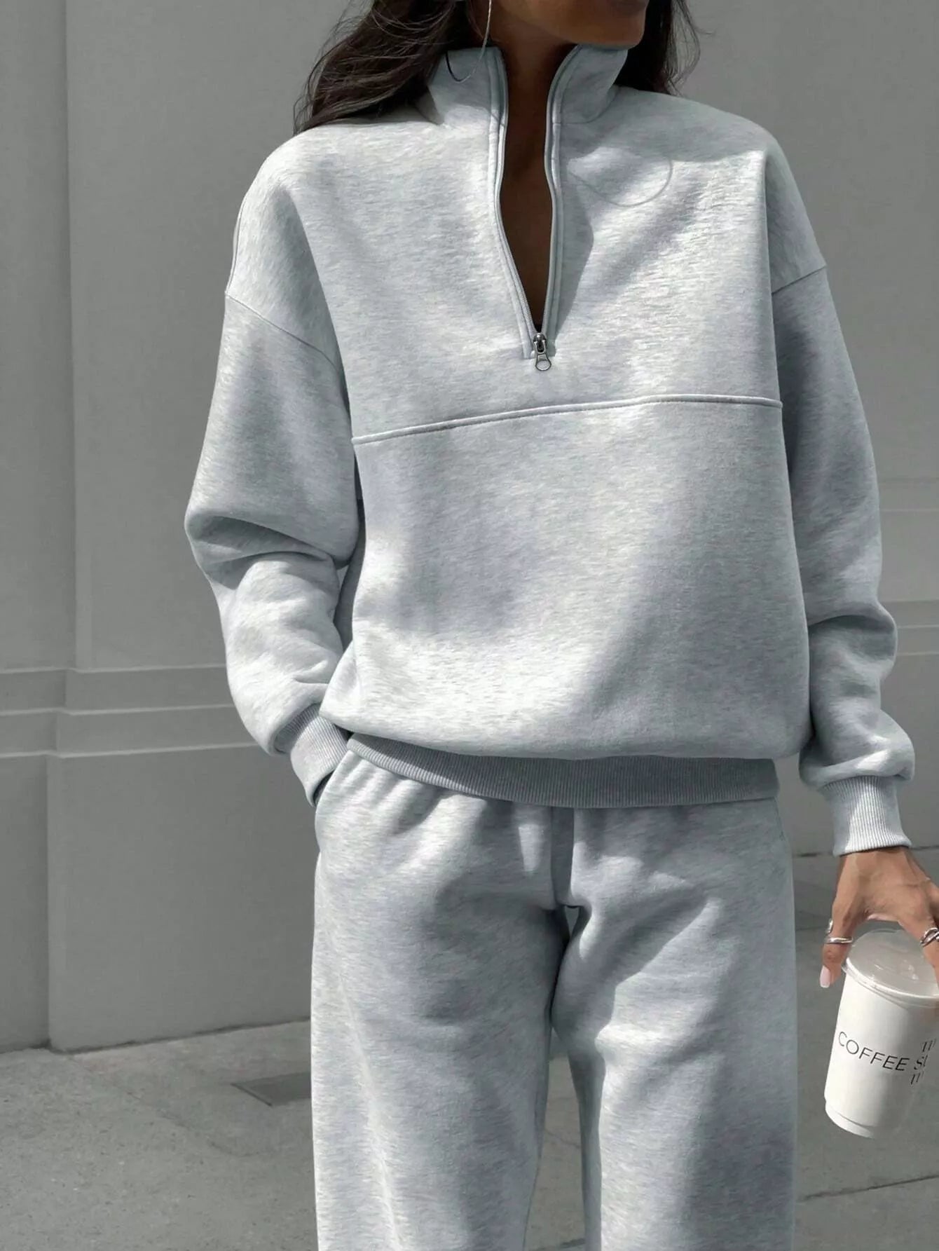 Light gray half zip sweatshirt and matching sweatpants set with crewneck and elastic cuffs.