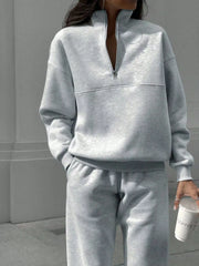 Light gray half zip sweatshirt and matching sweatpants set with crewneck and elastic cuffs.