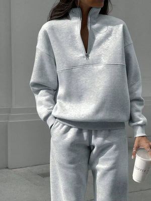 Light gray half zip sweatshirt and matching sweatpants set with crewneck and elastic cuffs.