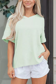 Relaxed V-neck waffle knit t-shirt in light green with cuffed short sleeves.