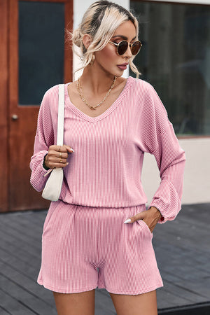 Blush pink ribbed outfit set with v-neck top and shorts, styled with a white crossbody bag.