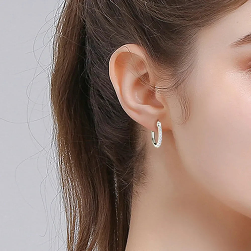 Silver pave-set mini hoop earrings with sparkling stones.