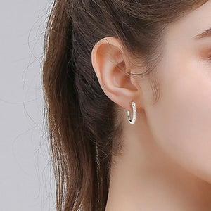 Silver pave-set mini hoop earrings with sparkling stones.