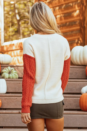 Cream sweater with textured orange sleeves, crew neck, acrylic blend.