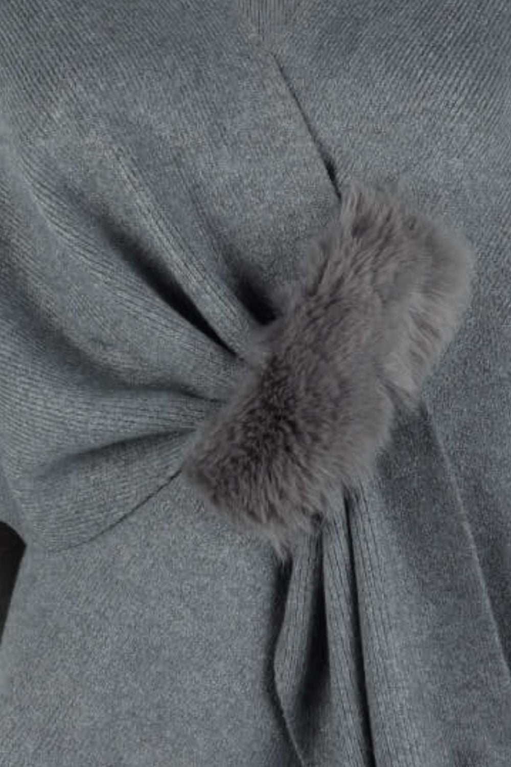 Charcoal knit cape with draped detail and fur trim accent.