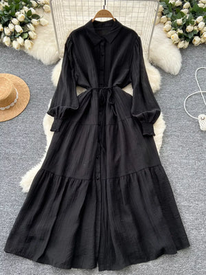 Black textured tiered long sleeve midi dress with button-down front and tie waist.