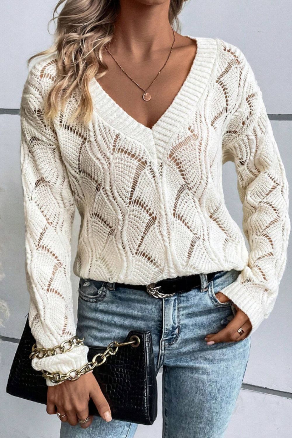 Ivory openwork knit V-neck pullover sweater with a detailed diamond pattern.
