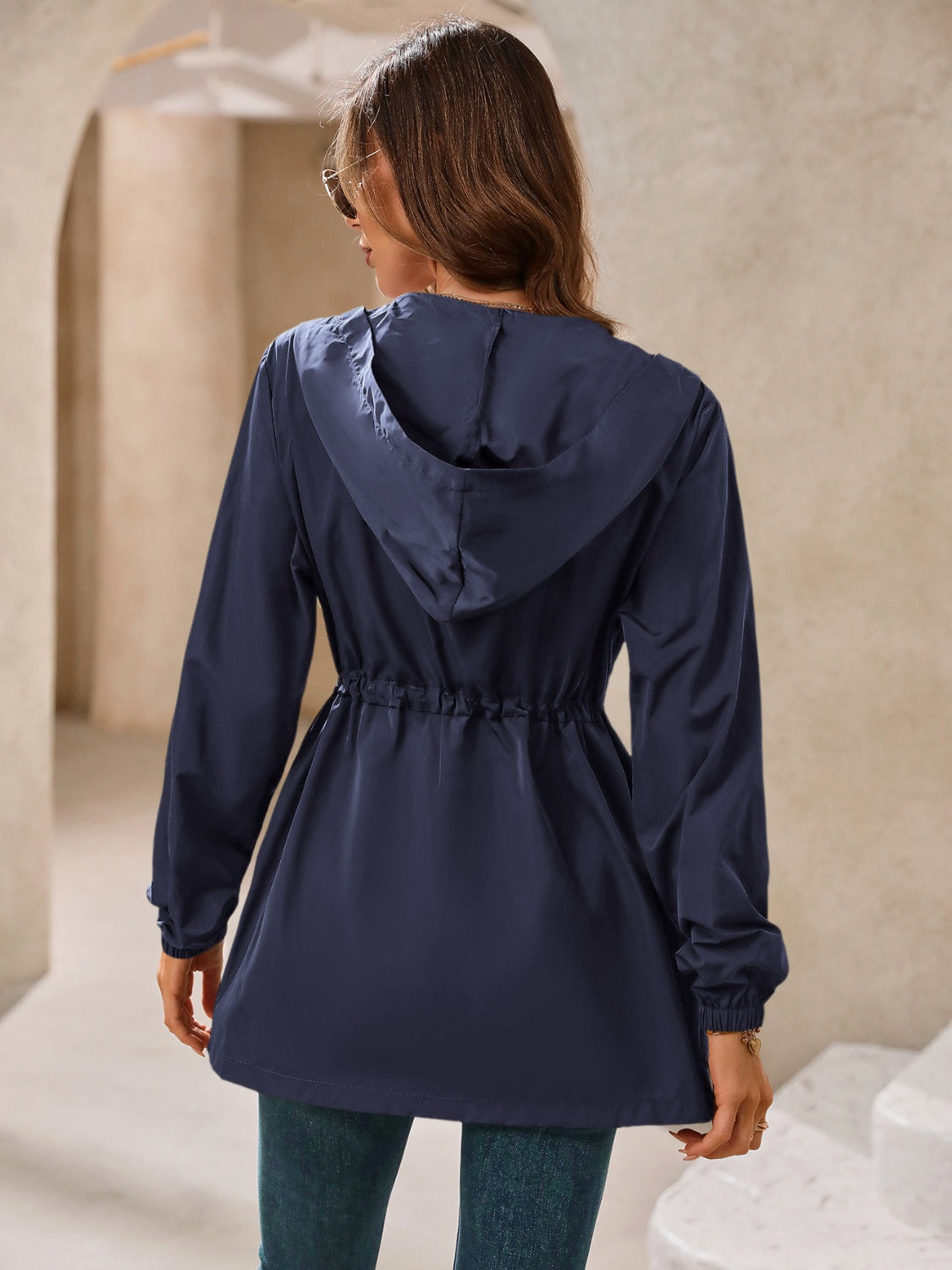Navy hooded jacket with cinched waistline and elastic cuffs