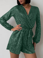 Dark green sequin wrap romper with blouson sleeves and tie waist.