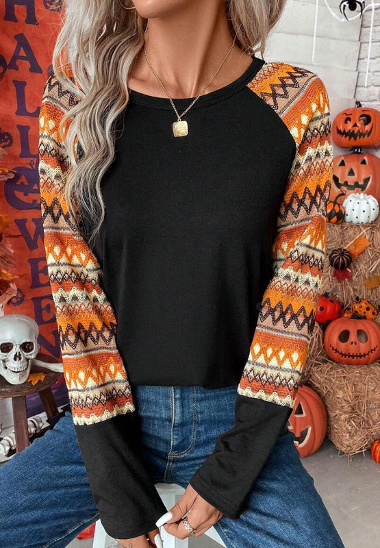 Black raglan tee with Aztec print sleeves in orange and cream, crew neck, long sleeves.