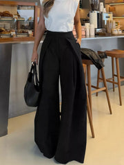 Black wide-leg pants with a high waist and pleated detail, styled with a white top.