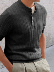 Textured ribbed knit polo shirt in black with short sleeves and a buttoned neckline.